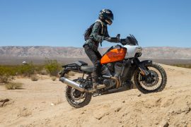 Is Harley’s New Pan America the Perfect Adventure Bike for Women? Woman riding an adventure bike up a sandy hill